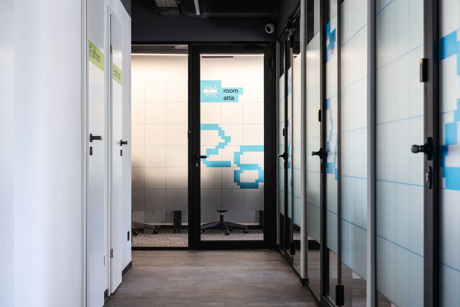 An office corridor leading to a set of doors